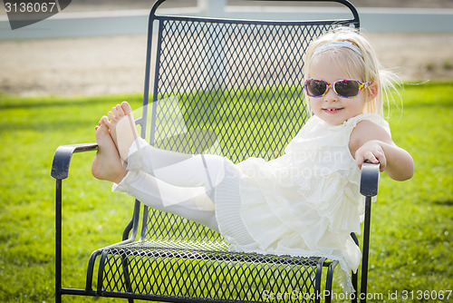 Image of Cute Playful Baby Girl Wearing Sunglasses Outside at Park