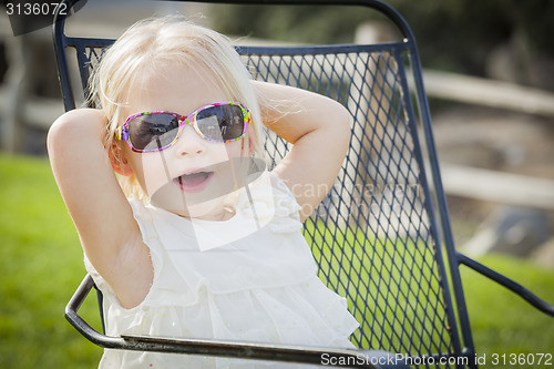 Image of Cute Playful Baby Girl Wearing Sunglasses Outside at Park