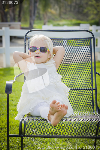 Image of Cute Playful Baby Girl Wearing Sunglasses Outside at Park