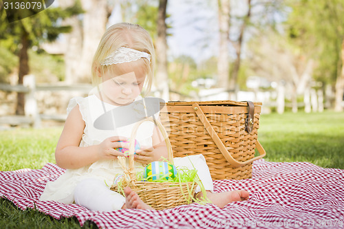 Image of Cute Baby Girl Enjoying Her Easter Eggs on Picnic Blanket