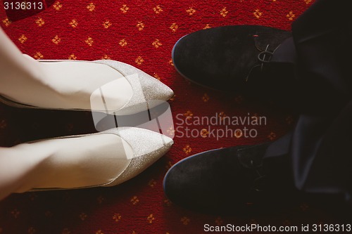 Image of Bride's and groom's shoes on carpet.