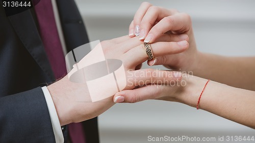 Image of Bride putting a wedding ring