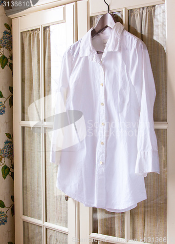 Image of white cotton shirt on a hanger