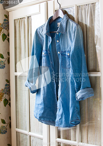 Image of denim shirt on a hanger