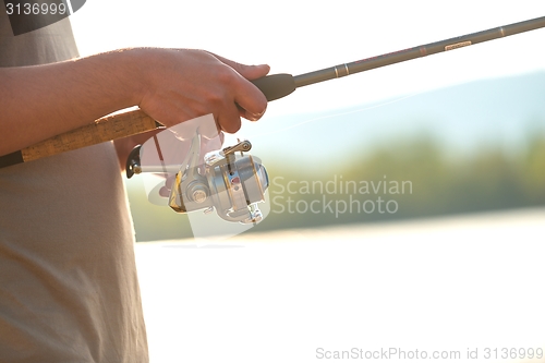 Image of Modern clean fishing rod in hands