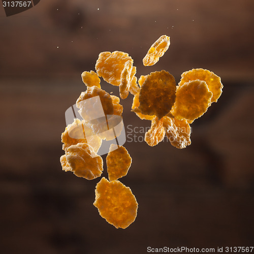 Image of Falling corn flakes on wooden background