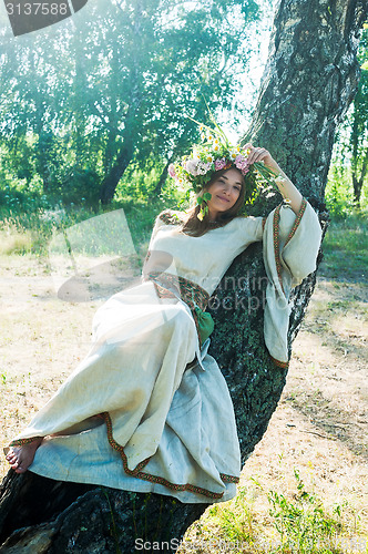 Image of Young beautiful woman with flower wreath laying