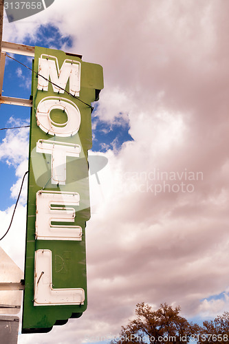 Image of Neon Motel Sign Clear Blue Sky White Billowing Clouds