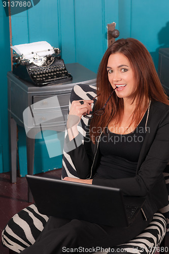 Image of Redhead Woman Sitting Office Setting Working Computer Laptop