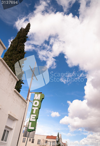 Image of Neon Motel Sign Clear Blue Sky White Billowing Clouds