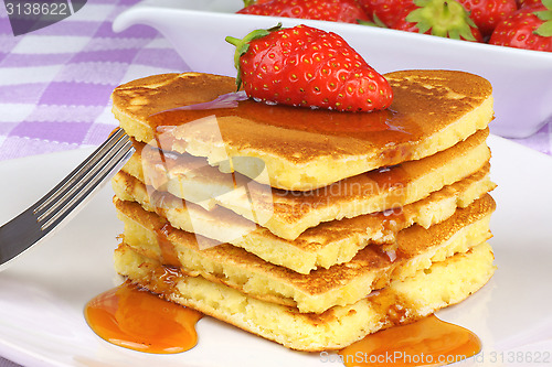 Image of Heart-shaped pancakes with syrup and strawberry