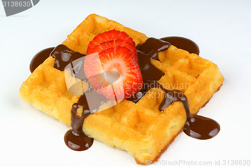 Image of Waffle with strawberry slices and chocolate sauce