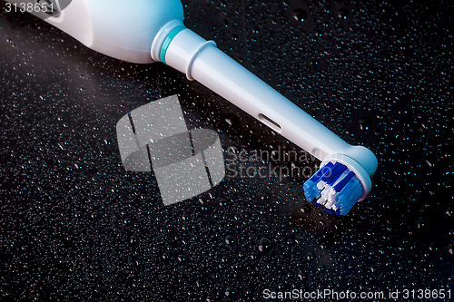Image of White Electric Toothbrush on Black 