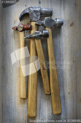 Image of four different hammer on a wooden