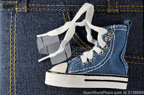 Image of tiny blue shoe on denim background