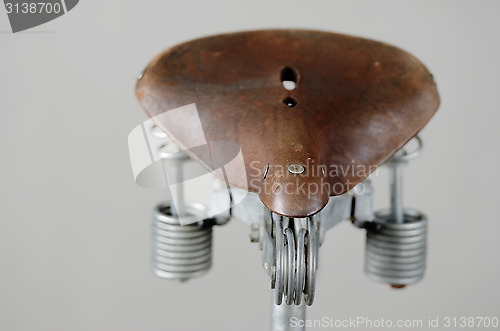 Image of old-fashioned vintage leather bike saddle with spring