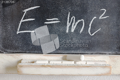Image of well-known physical formula written in chalk on the blackboard