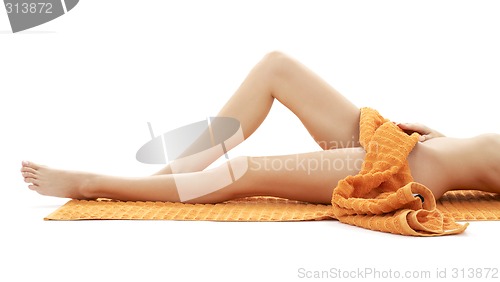 Image of long legs of relaxed lady with orange towel