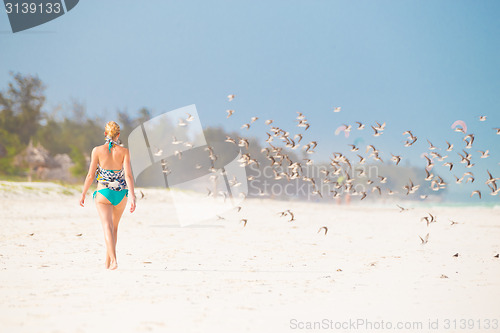 Image of Woman walking on the beach.