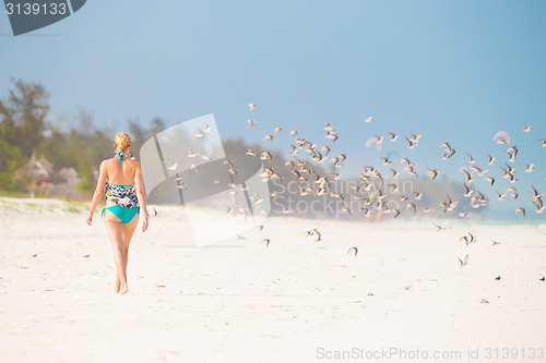 Image of Woman walking on the beach.