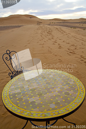 Image of table and seat in sand