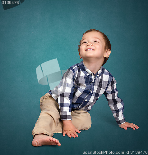 Image of Cute boy siting on the floor