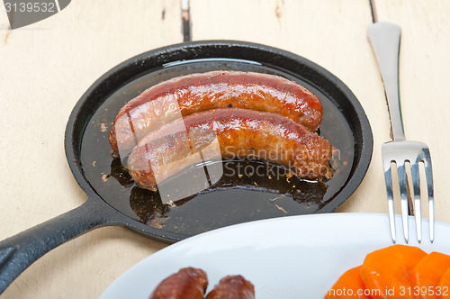 Image of beef sausages cooked on iron skillet 