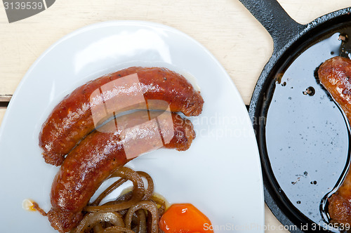 Image of beef sausages cooked on iron skillet 