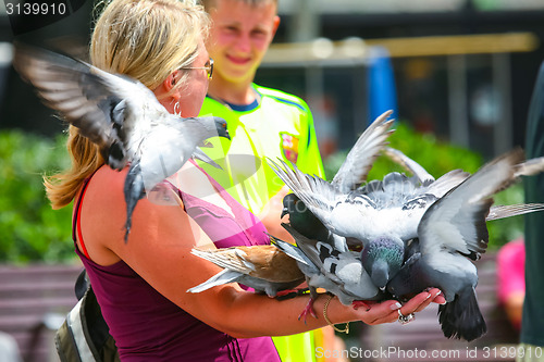 Image of Woman holding group of pigeons