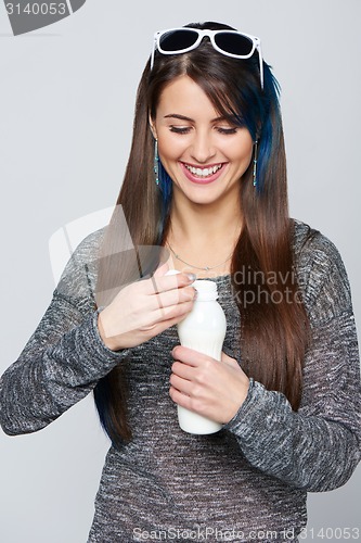 Image of Healthy woman opening a bottle of dairy produce