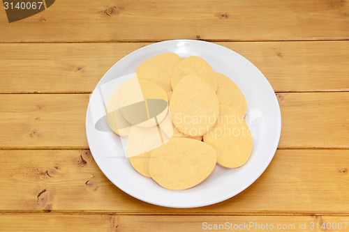 Image of Pile of egg-shaped biscuits on a white plate