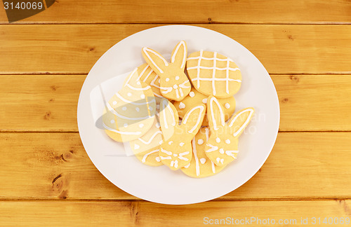 Image of Plate full of frosted Easter cookies on a wooden table