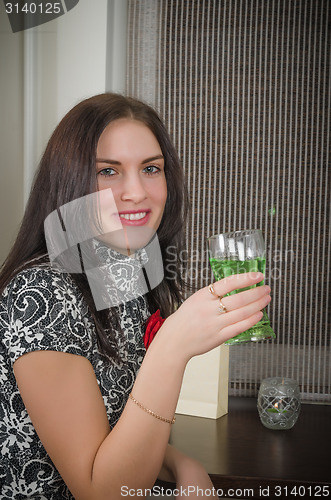 Image of young beautiful woman drinks a cocktail 