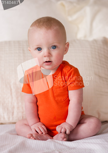 Image of Young Blue Eyed Infant Boy Sitting up Looking at Camera