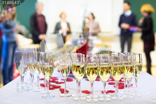 Image of Banquet event. Waiter pouring champagne into glass.