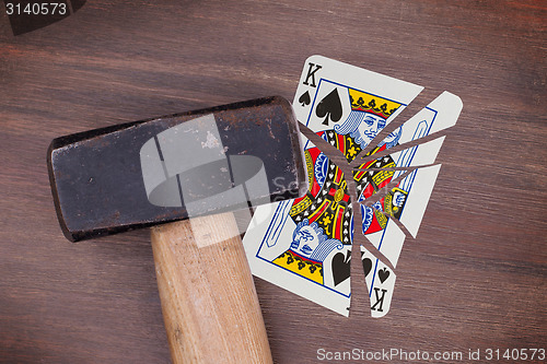 Image of Hammer with a broken card, king of spades