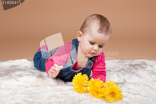 Image of small infant baby with yellow flowers