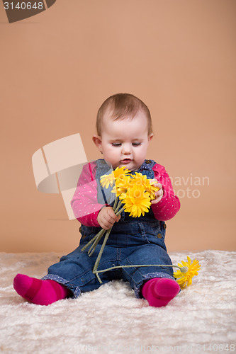 Image of infant baby with yellow flowers