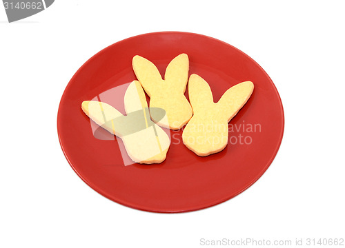 Image of Three rabbit-shaped cookies for Easter on a red plate