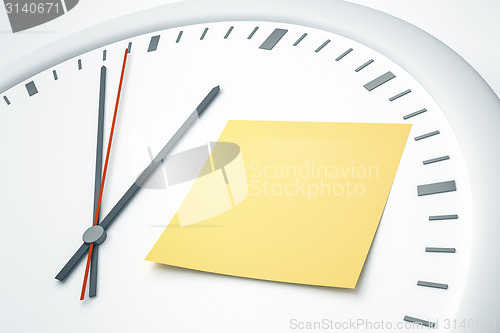 Image of clock with sticky note