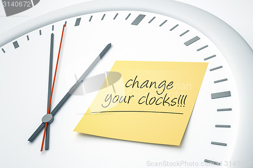 Image of clock with sticky note