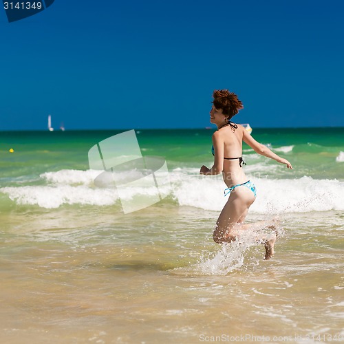 Image of woman splashing water in the ocean