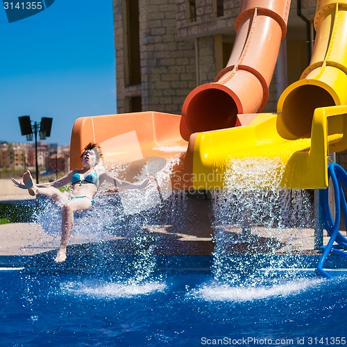 Image of Happy woman sliding water park.