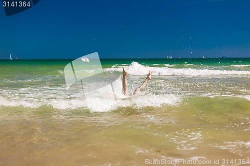 Image of woman splashing water in the ocean