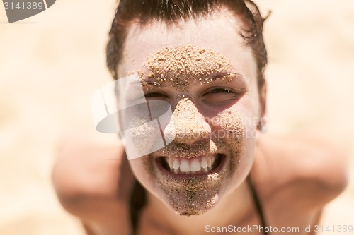 Image of Beautiful girl with sand on face