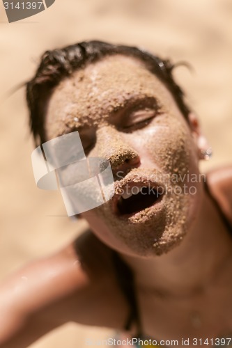 Image of Beautiful girl with sand on face