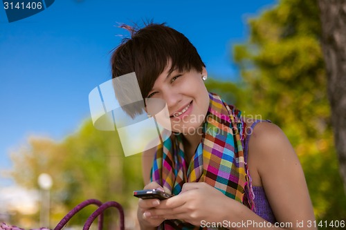 Image of Young beautiful woman writes an SMS