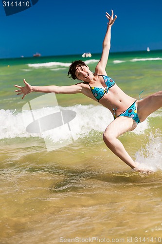 Image of woman splashing water in the ocean