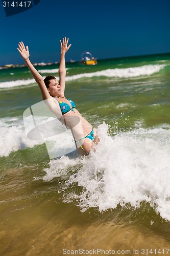 Image of woman splashing water in the ocean