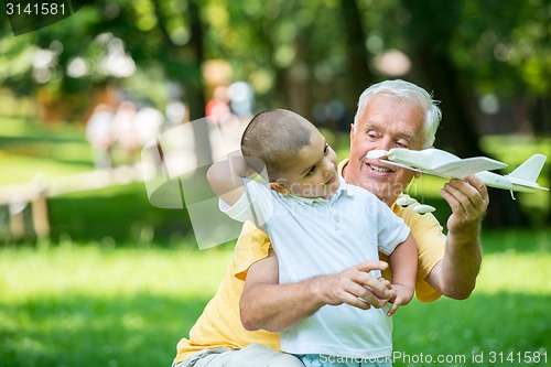 Image of grandfather and child have fun  in park